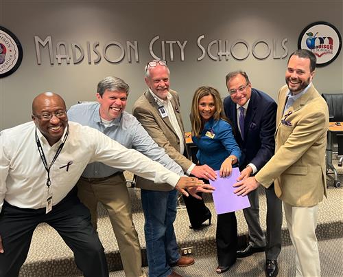 board members around a purple folder